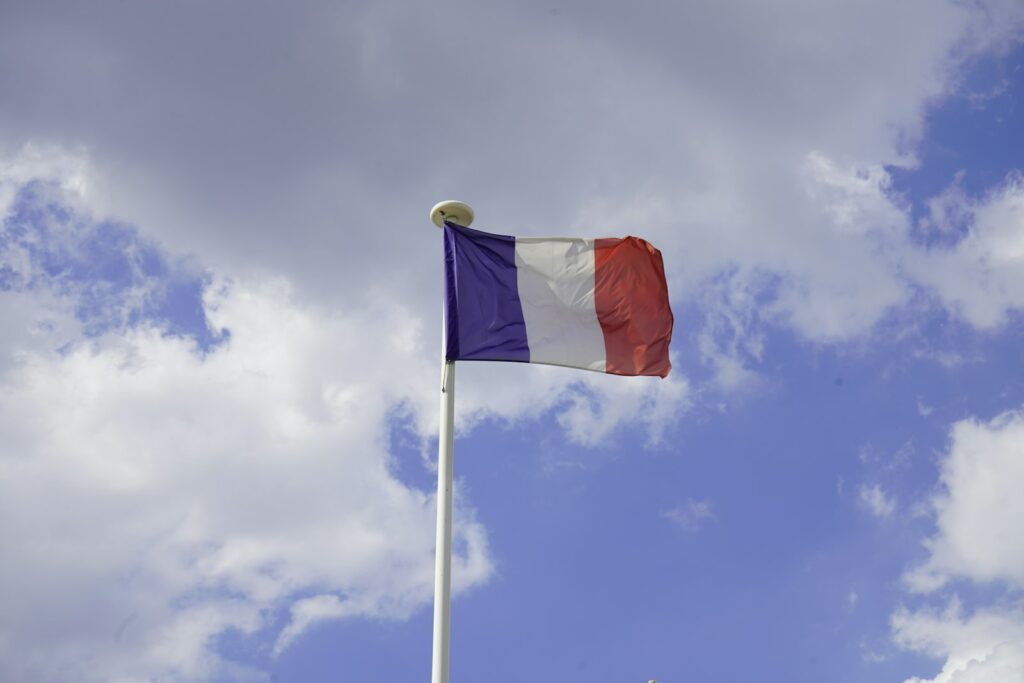 Drapeau français flottant, image d’illustration pour un article sur la vie politique et le gouvernement.